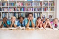 Teacher and kids lying on floor in library Royalty Free Stock Photo