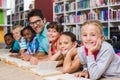 Teacher and kids reading book in library Royalty Free Stock Photo