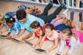 Teacher and kids using digital tablet in library Royalty Free Stock Photo