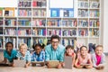 Teacher and kids using digital tablet in library Royalty Free Stock Photo