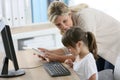 Teacher and little girl using computer and tablet Royalty Free Stock Photo