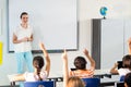 Teacher looking at students raising their hands Royalty Free Stock Photo