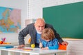 Teacher with male elementary school pupil with problem. Pupil and Teacher in classroom. Royalty Free Stock Photo