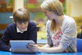 Teacher With Male Pupil Using Digital Tablet In Classroom Royalty Free Stock Photo