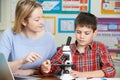 Teacher With Male Student Using Microscope In Science Class Royalty Free Stock Photo