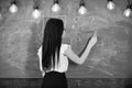 Teacher of mathematics writing on chalkboard, rear view. Lady teacher in glasses explaining formula. teacher