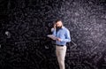 Teacher with notebook against big blackboard with symbols and fo