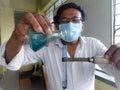 A teacher performing biochemistry tests infront of his students.