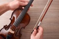 Teacher picking up 1/2 student violin from a wooden table