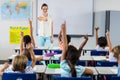 Teacher pointing students with raised hands