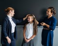 The teacher praises the schoolgirl in front of her mother standing at the blackboard.