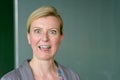 Teacher pulling an aghast face in front of blackboard Royalty Free Stock Photo