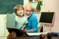 Teacher and pupil learning together in school. Grandfather and grandson. Father and son.