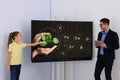 Teacher and pupil using interactive board in classroom during lesson Royalty Free Stock Photo