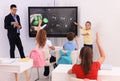 Teacher and pupil using interactive board in classroom during lesson Royalty Free Stock Photo