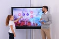 Teacher and pupil using interactive board in classroom during lesson Royalty Free Stock Photo