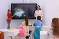 Teacher and pupil using interactive board in classroom during lesson Royalty Free Stock Photo