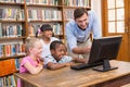 Teacher and pupils using computer at library Royalty Free Stock Photo