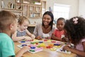 Teacher And Pupils Using Flower Shapes In Montessori School Royalty Free Stock Photo