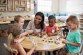 Teacher And Pupils Using Wooden Shapes In Montessori School Royalty Free Stock Photo