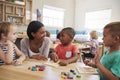 Teacher And Pupils Using Wooden Shapes In Montessori School Royalty Free Stock Photo