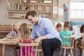 Teacher And Pupils Using Wooden Shapes In Montessori School Royalty Free Stock Photo