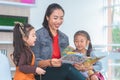 Teacher reading story book to kindergarten students laughing Royalty Free Stock Photo