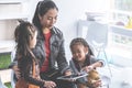 Teacher reading story book to kindergarten students with tabl Royalty Free Stock Photo