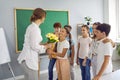 Teacher's Day. Elementary school children give the teacher a bouquet of flowers for the holiday.