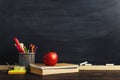 Teacher`s desk with writing materials, a book and an apple, a blank for text or a background for a school theme. Copy space