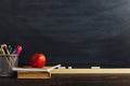 Teacher`s desk with writing materials, a book and an apple, a blank for text or a background for a school theme. Copy space Royalty Free Stock Photo