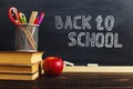 Teacher's desk with writing materials, a book and an apple, a blank for text or a background for a school theme. Copy space Royalty Free Stock Photo