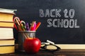 Teacher's desk with writing materials, a book and an apple, a blank for text or a background for a school theme. Copy space Royalty Free Stock Photo