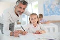 Teacher with schoolgirl in class wirting Royalty Free Stock Photo