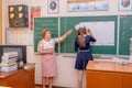 The teacher and schoolgirl of the middle school near a chalkboard