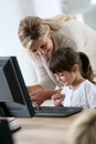 Teacher showing little pupil girl how to use computer Royalty Free Stock Photo