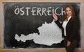 Teacher showing map of austria on blackboard