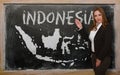 Teacher showing map of indonesia on blackboard