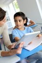 Teacher showing school boy how to use tablet Royalty Free Stock Photo