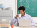 Teacher sipping coffee and working on laptop Royalty Free Stock Photo
