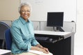 Teacher Sitting In Classroom