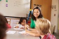 Teacher sitting with kids in elementary school lesson Royalty Free Stock Photo