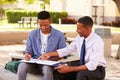 Teacher Sitting Outdoors Helping Male Student With Work Royalty Free Stock Photo