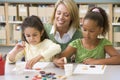 Teacher sitting with students in art class,