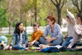 Teacher with small children sitting outdoors in city park, learning group education concept.