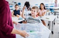 A teacher with small school kids in classroom learning about waste separation.