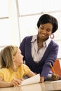 Teacher Smiling and Helping Student