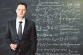 The teacher stands in front of the school blackboard on which is Royalty Free Stock Photo