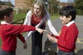 Teacher Stopping Two Boys Fighting In Playground Royalty Free Stock Photo