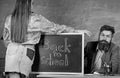 Teacher strict sit table chalkboard background. Student in mini skirt with nice buttocks stand near blackboard. School